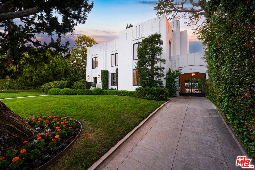 The Smith House at twilight, a 1929 Art Deco mansion in Hancock Park with stepped white-stucco massing under a violet sky.